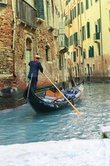 Fototapeta na wymiar Gondolier on canal, in Venice