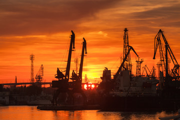 Silhouettes of cranes and ships in port of Varna