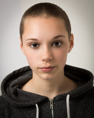 Beautiful Young Teenager With Shaven Head and Wearing a Hoodie