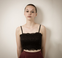 Shaven Bald Teenage Girl With Black Top and Bare Shoulders