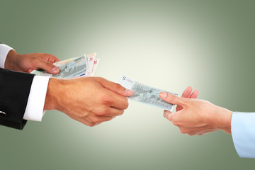 Woman hand takes money from the man's hand on green background