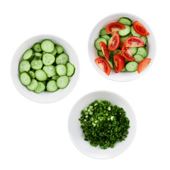 Fresh tomatoes, cucumbers and green onions chopped in salad. Three plates of salad isolated on a white background.