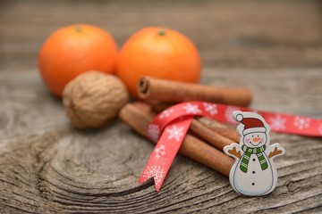 Christmas composition with fresh mandarin oranges, cinnamon and walnut on wooden background