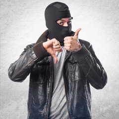 Robber making good-bad sign