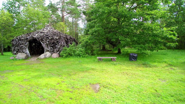 Closer look of the Enumagi hill in Estonia with lots of green trees in the forest and the structures made in small branches of trees