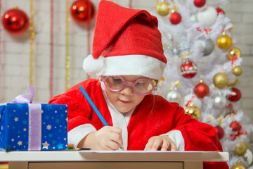 Obraz na płótnie Canvas Girl enthusiastically prepares a gift card for Christmas