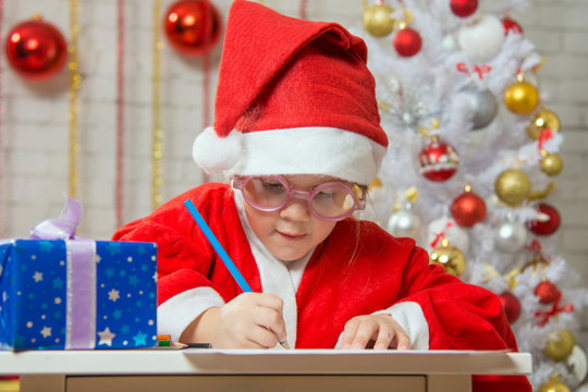 Girl enthusiastically prepares a gift card for Christmas