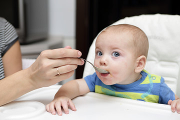 Baby has breakfast in highchair