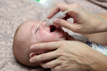 Mother using baby's nasal aspirator