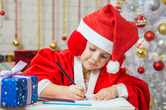 Girl with enthusiasm writes congratulations Christmas card