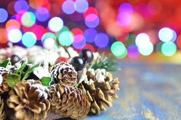 dekoracja bożonarodzeniowa, wieniec zrobiony z szyszek na tle bokeh 