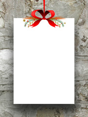 Single empty rectangular paper sheet frame with Xmas ribbon decoration on ancient stone wall background 