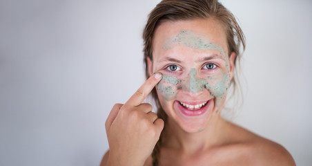 Beautifu toplessl woman with facial mask having her eyes closed.