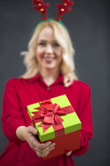 Happy smiling Santa girl with gift box enjoying falling snowflak