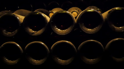Dusty wine bottles on the shelf in the cellar. The cellar is a storage room for wine bottles and wine barrels