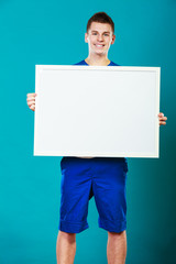 man holding blank presentation board on blue