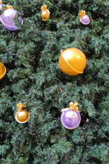 Green pine needles of the Christmas tree with colorful toys and electric holiday garland