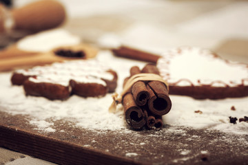 Gingerbread cookies, spices and flour over wooden background
