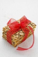 Stack Cereal cookies tied with red ribbon on a white wooden tabl