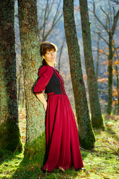 Woman in red dress portrait, autumnal forest