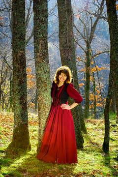 Woman in red dress portrait, autumnal forest