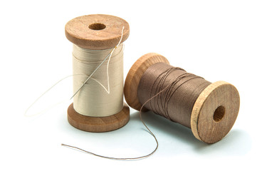 Isolated wooden spool of thread and needle