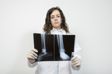 Fototapeta premium Female doctor examining accurately a foot x-ray.