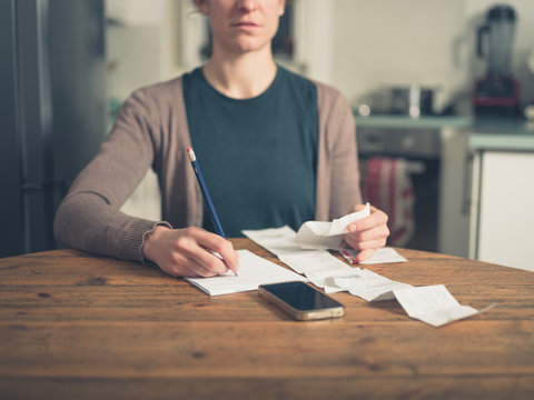 Woman looking at receipts at home