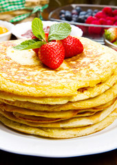 stack of freshly prepared traditional pancakes with strawberries