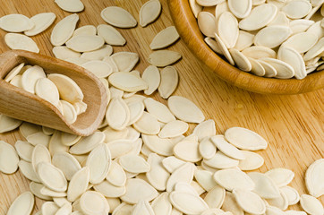 dried pumpkin seeds, on wooden background.