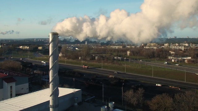 AERIAL. Point of interest (orbit) flight around factory chimney with grey smoke. Industrial pollution