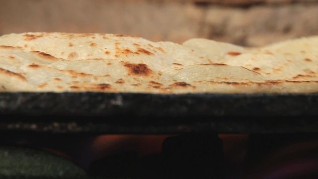 Traditional thin pitta bread being cooked at the gas stove in Curepipe, Mauritius.
