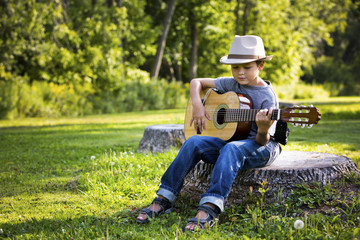 Naklejka na ściany i meble portrait of a little boy with guitar