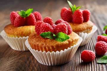 Delicious cupcakes with berries and fresh mint on wooden table close up