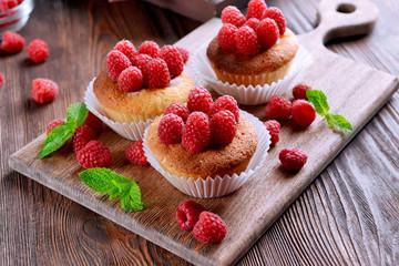 Delicious cupcakes with berries and fresh mint on wooden table close up