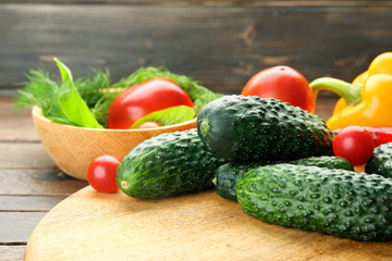 Composition of cucumbers, tomatoes and sweet peppers circles on wooden background
