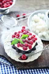 Sweet cakes with raspberries on wooden table background