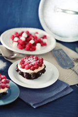 Sweet cakes with raspberries on color wooden background