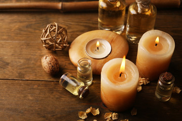 Beautiful decorated composition with candles, pebbles and bamboo on wooden background