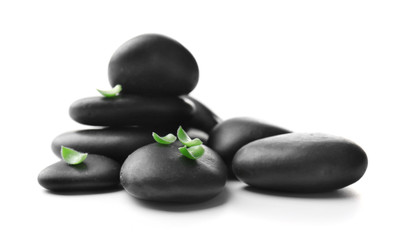 Stack of stones and a green flower, isolated on white. Spa relaxation concept