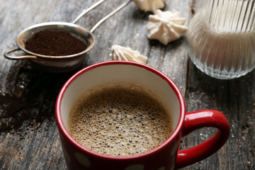 Cup of coffee with sweets on wooden background