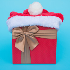 present box with santa claus hat on top on blue