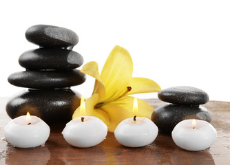 Fototapeta na wymiar Spa stones with candles and lily, isolated on white