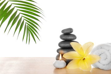 Spa stones with candle, towel and lily, isolated on white