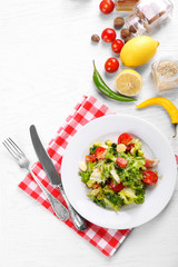 Tasty salmon salad on light wooden background