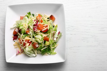 Tasty salmon salad on light wooden background