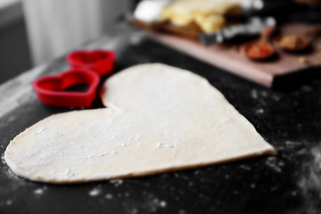 Uncooked heart shaped biscuit on a table