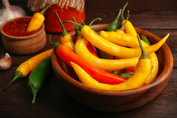 Chili peppers, homemade sauce salsa and spices on  wooden background