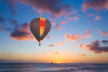 Fototapeta na wymiar Hot air balloon over sunset sea