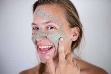 Beautifu toplessl woman with facial mask having her eyes closed.